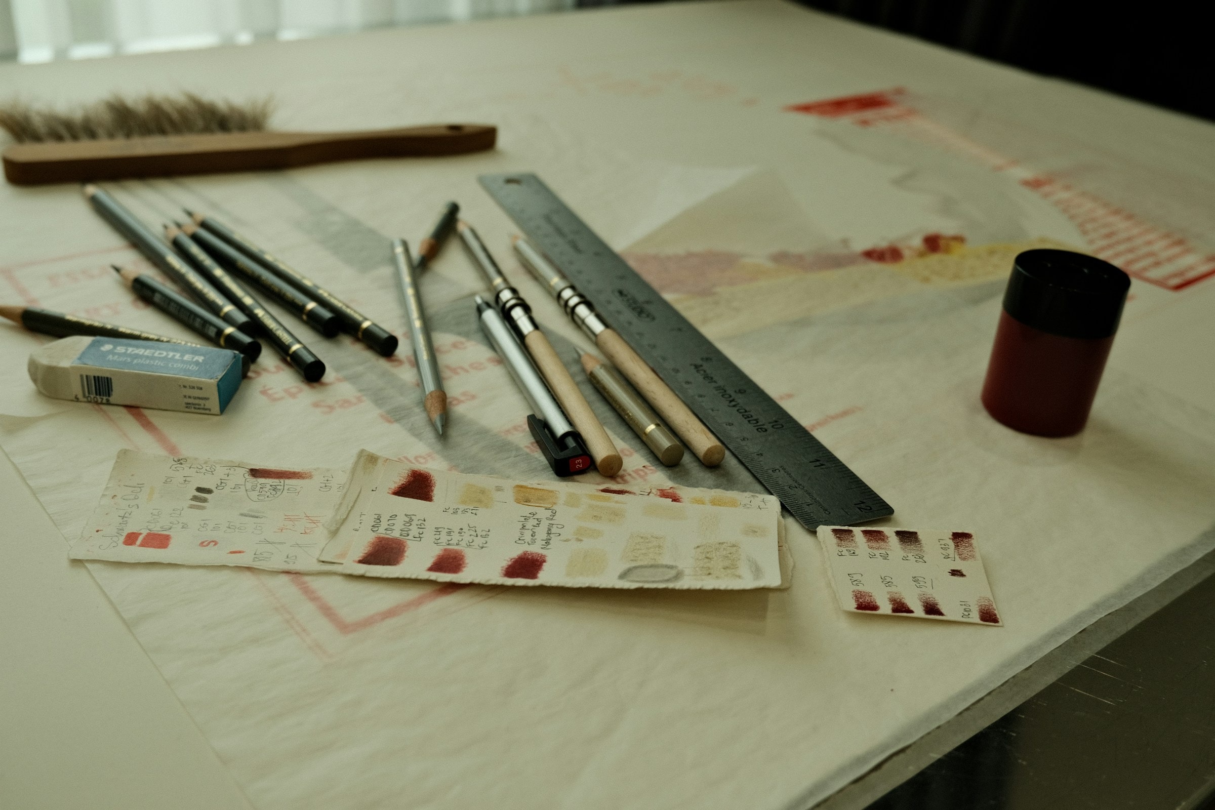 Drawing and painting supplies spread across a work table